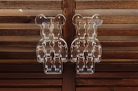 two plastic bears sitting on a wooden bench