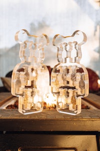 two teddy bears sitting on a table in front of a fireplace